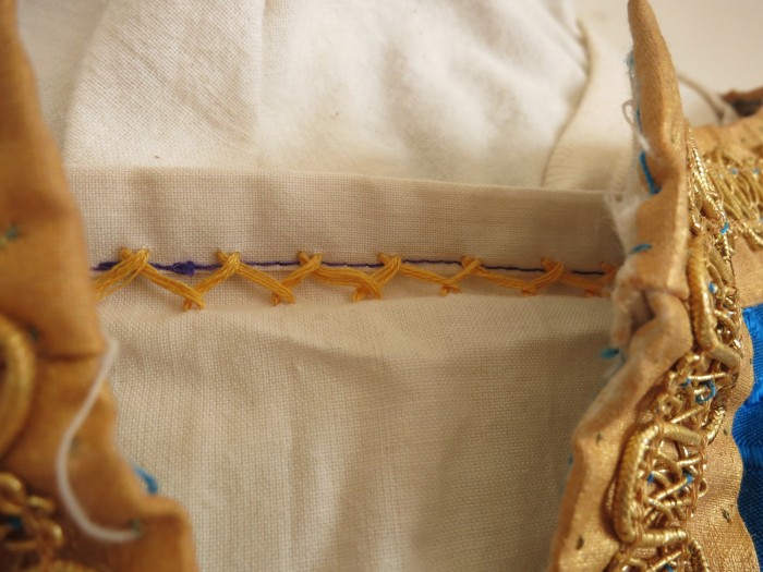 Underdress collar detail. Mysterious use of purple thread. 